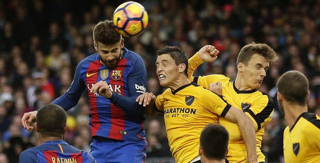 Piqu&eacute; remata durante el partido ante el M&aacute;laga.