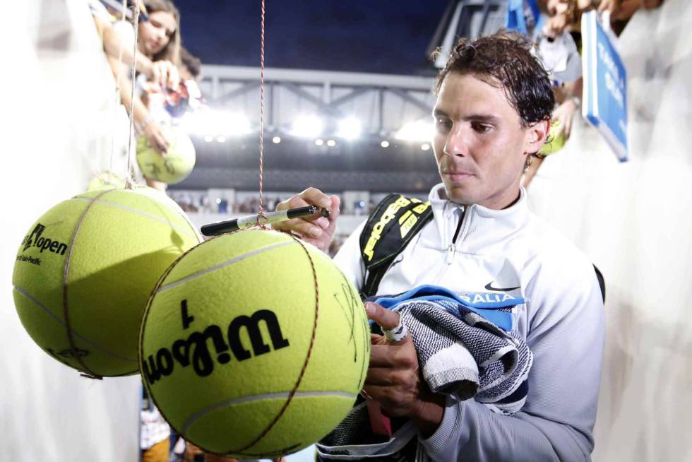 Nadal firma pelotas al finalizar el partido de la tercera ronda.