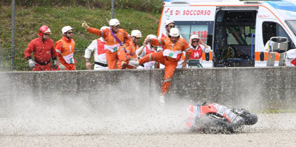 Los comisarios saltan a la pista para atender a Pirro, su moto todavía rueda por la grava.