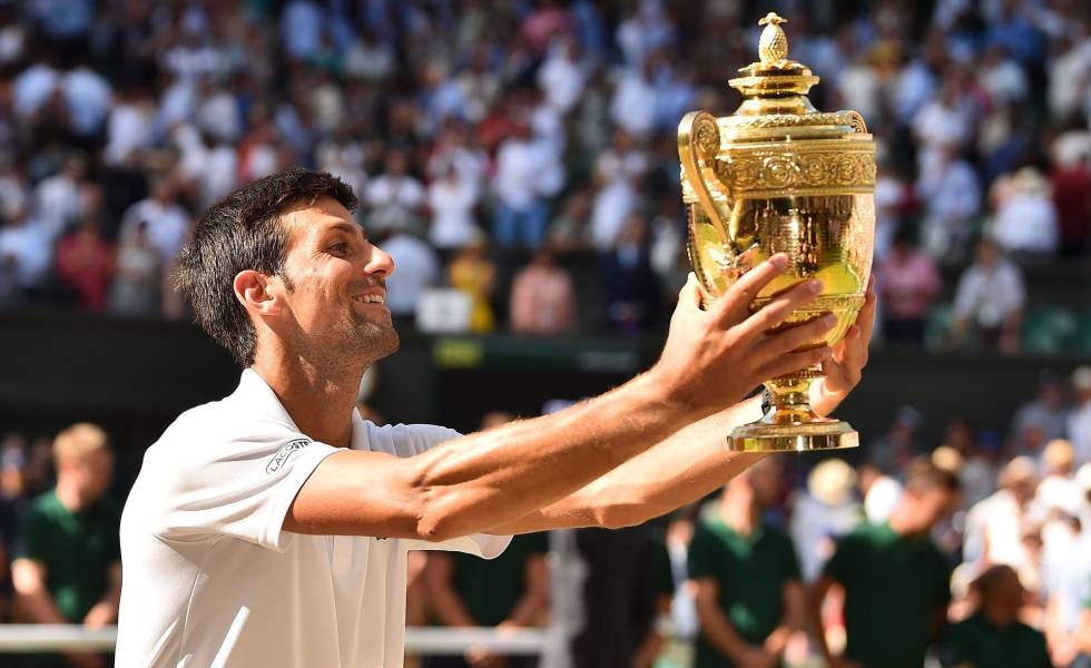 Djokovic observa su trofeo de campeón en Wimbledon.