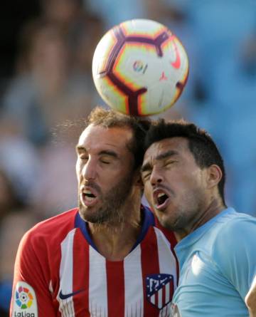 Godín y Cabral disputan la pelota.