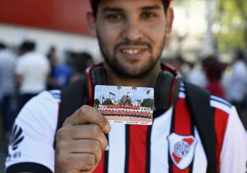 Un aficionado de River enseña su entrada para la final.