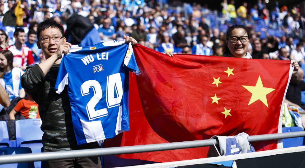 Aficionados chinos con la bandera de su país y una camiseta de Wu Lei en Cornellà.