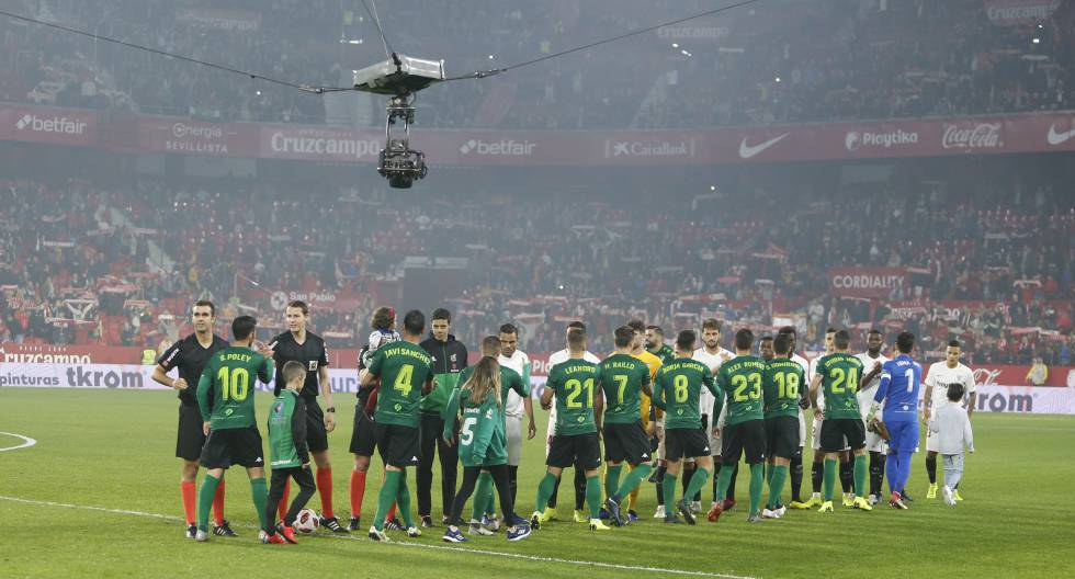 Una cámara aérea muestra el saludo de los jugadores antes del comienzo de un partido.