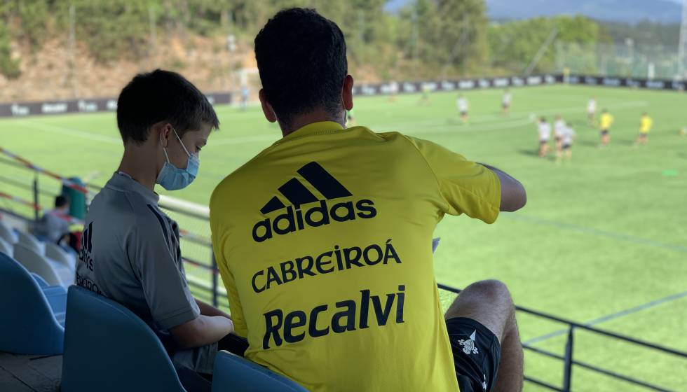 Un niño de la cantera del RC Celta revisa con su entrenador unos de los informes sobre su desempeño en A Madroa.