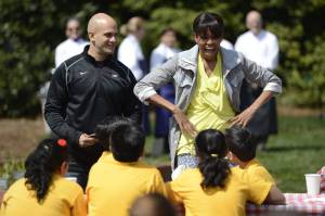 La primera dama estadounidense, Michelle Obama (d) y el jefe de cocina de la Casa Blanca y asesor de la política nutricional de la administración Obama, Sam Kass (i) animan a varios niños a participar en la quinta edición de cultivo de la Casa Blanca celebrada en el jardín sur de la residencia presidencial en Washington, Estados Unidos.