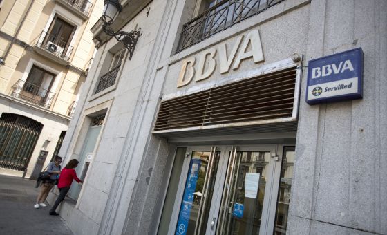 Dos clientes sacan dinero en un cajero de BBVA.