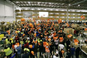Fotografía distribuida por Amazon donde los empleados del centro logístico de Madrid celebran el anuncio de la ampliación del almacén