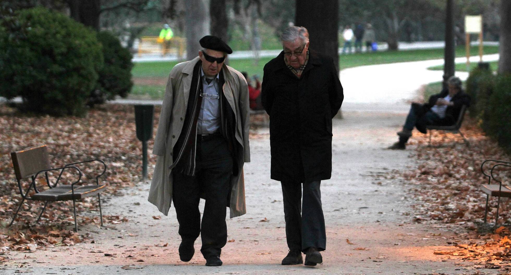 Dos personas mayores caminan por un parque en Madrid. Dos personas mayores caminan por un parque en Madrid.