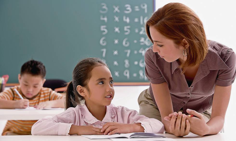 Una maestra dando clase a unos niños.