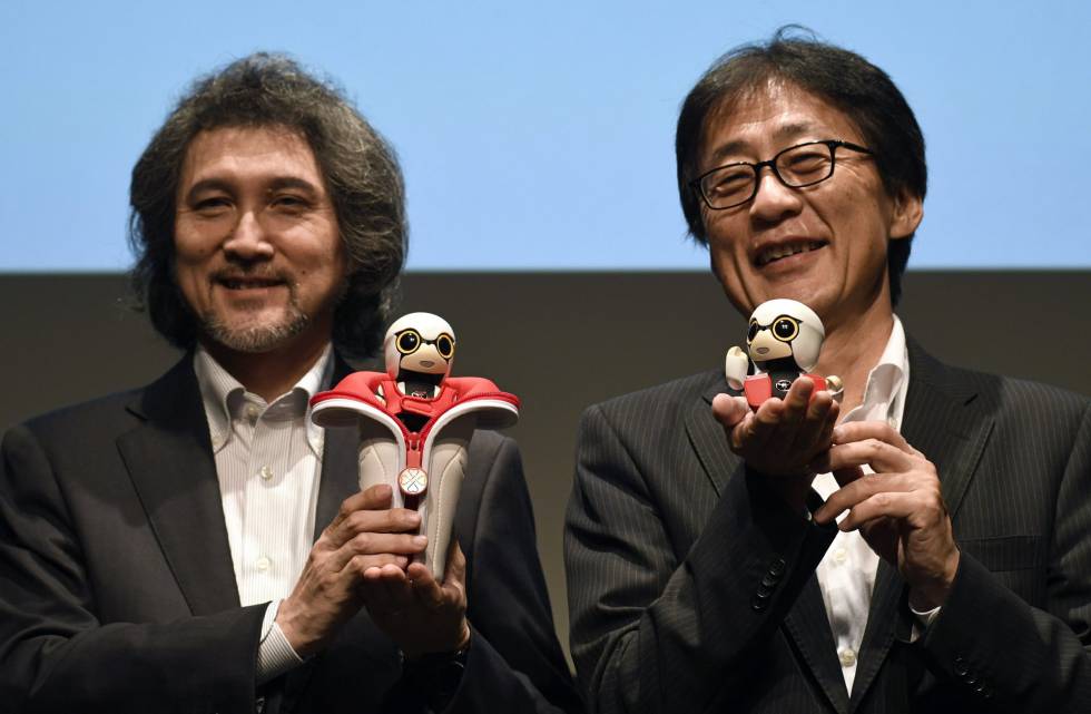 Dos ejecutivos de Toyota, responsables del proyecto de robótica, sujetan dos Kirobo Mini. El de la izquierda, con la funda para colocarlo en el posavasos del coche Dos ejecutivos de Toyota, responsables del proyecto de robótica, sujetan dos Kirobo Mini. El de la izquierda, con la funda para colocarlo en el posavasos del coche