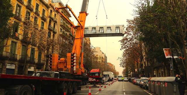 Una grúa coloca el ático de La Casa por el Tejado en la finca de la calle de Aragón, en Barcelona.