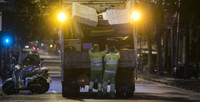Operarios de FCC recogen muebles y trastos viejos en el distrito del Eixample de Barcelona.
