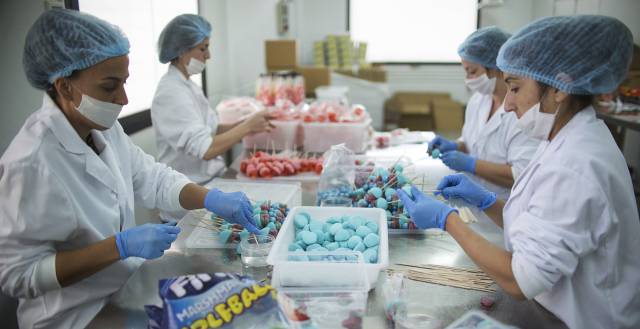 Varias mujeres confeccionan paquetes de productos Wonkandy en la planta sevillana de la empresa