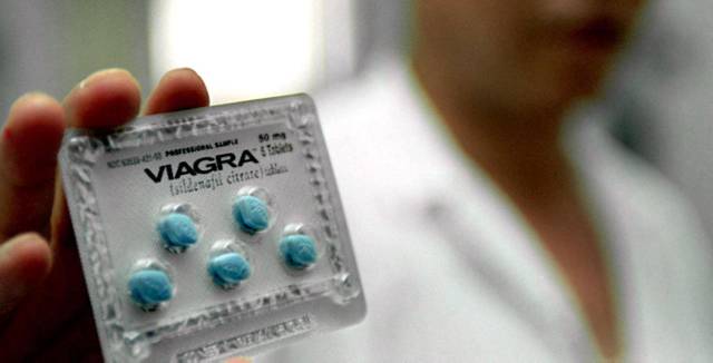 Un doctor muestra píldoras del tratamiento Viagra de Pfizer