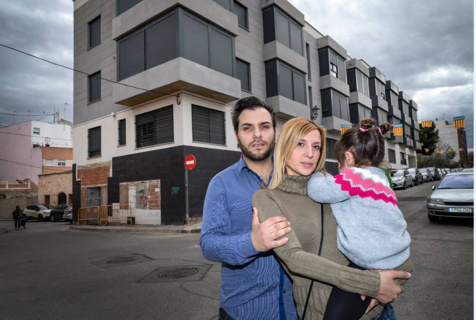 Luis Macía posa junto a su mujer y su hija frente a la urbanización de pisos inacabada en Benimamet.