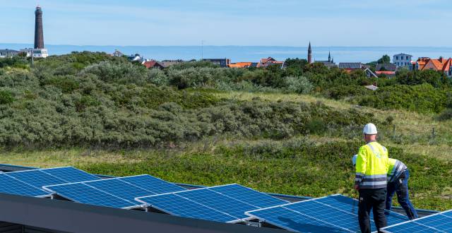 Dos obreros colocan paneles solares.
