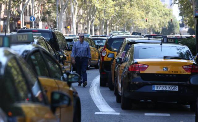 Un hombre camino entre los taxis parados durante la huelga de este lunes en Barcelona.