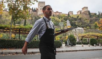 Un camarero en un restaurante del paseo de los Tristes en Granada.
