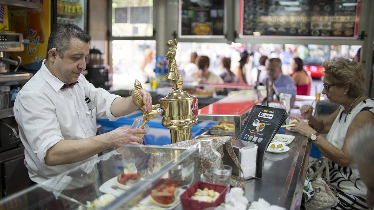 Un camarero tira una caña en un bar de Sevilla.