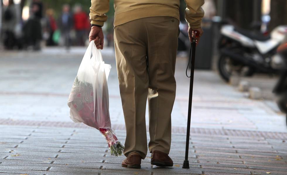Un anciano camina por una acera de Madrid.
