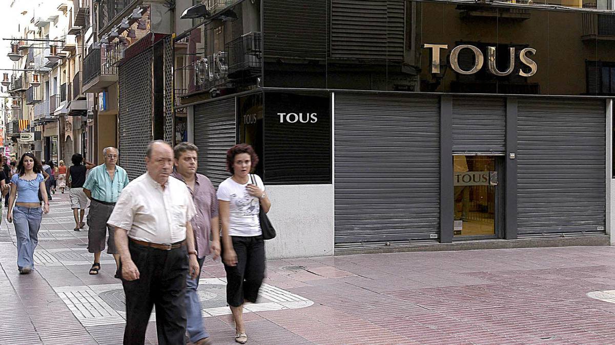 Unos viandantes, frente a una joyería Tous.