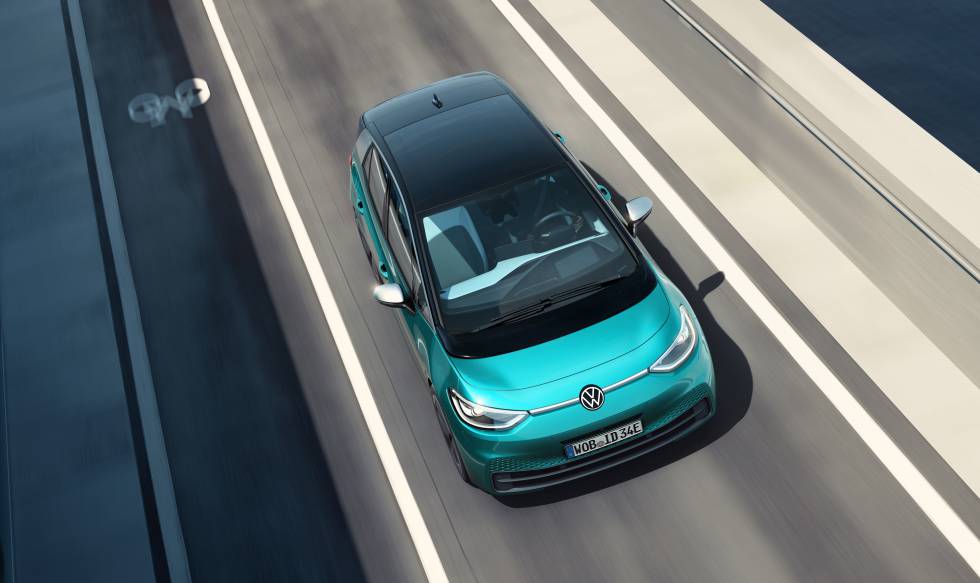 Un coche eléctrico Volkswagen ID.3 circula por una carretera junto a un carril bici.