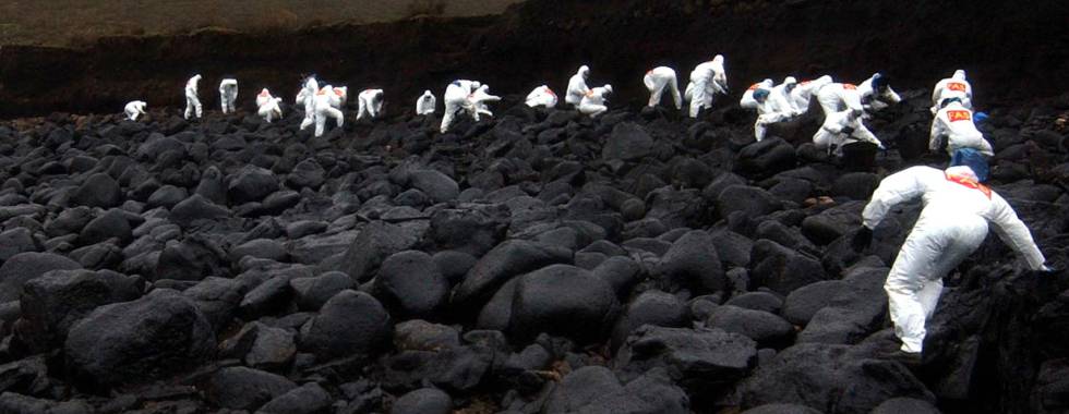 SOLDIERS FORM A LINE TO CLEAN UP FUEL OIL SPILLED FROM THE