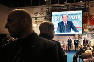 En la pantalla, Silvio Berlusconi durante un acto electoral. En la pantalla, Silvio Berlusconi durante un acto electoral.