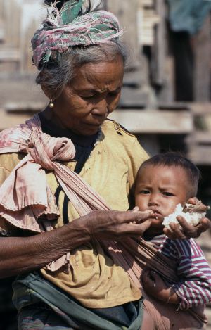 Una abuela alimenta a su nieto con arroz glutinoso, la base de la dieta laosiana y un alimento muy pobre que afecta al crecimiento físico e intelectual de los niños.