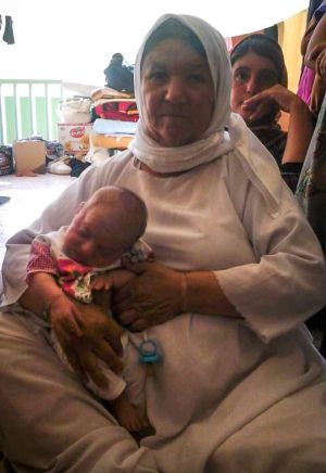 La abuela Gharib sostiene a Hyden en un colegio que acoge a familias desplazadas en Zakho, norte de Irak.
