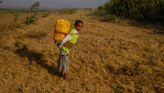 Una niña etíope carga con un contenedor de agua en su espalda. Una niña etíope carga con un contenedor de agua en su espalda.