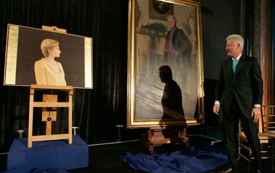 Clinton junto a su retrato y el de su esposa Hillary. l