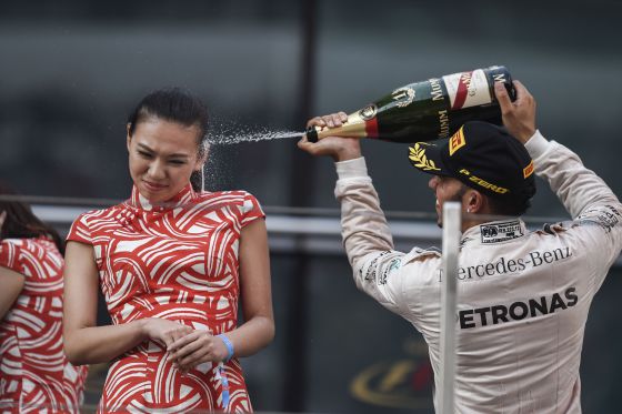 Lewis Hamilton celebra su triunfo en Shanghái rociando de champán a una azafata china