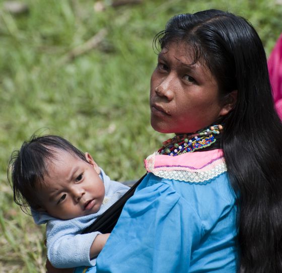 Una mujer carga a su bebé en una vereda en Colombia.