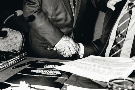 Dos delegados de alto nivel de la Confederación de la FIFA estrechan sus manos.