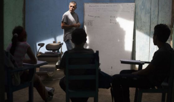 Varios alumnos atienden en clase.