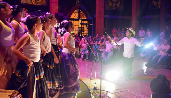 Sebastián Velasquez e os jovens de coral Chaminade dão um concerto de música colombiana para a comunidade do bairro Santo Domingo Savio.