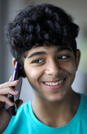 Udai, con el teléfono móvil con el que se comunica con su familia, con la que espera reunirse en Alemania.