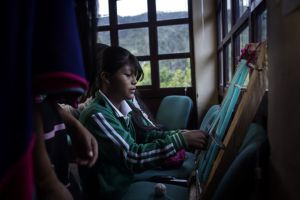 Una niña de etnia misak aprende a tejer en la Casa del Agua.