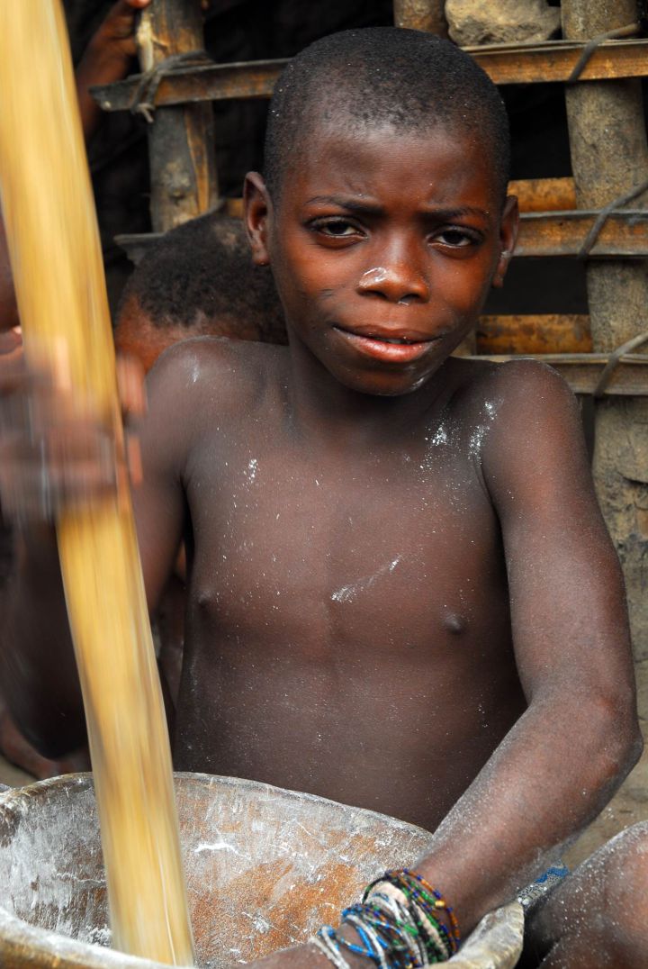Niño baka haciendo una pasta a base de yuca amarga. Niño baka haciendo una pasta a base de yuca amarga.