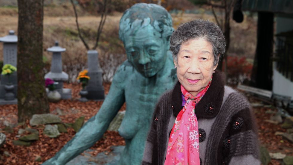 Il-chul frente a la obra “Mujer de la tierra”, del artista Ok-Sang Im, concebida para recordar los crímenes contra las mujeres de confort.