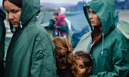 Migrantes hace cola para obtener comida en la frontera con Macedonia.  AFP