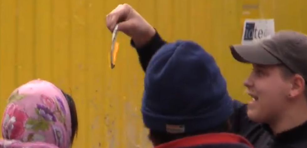Juegos de humillación: un hincha holandés quema un billete ante una mendiga