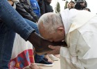 El Papa besa el pie de uno de los refugiados, nigeriano de confesión cristiana, en el centro de acogida de Castelnuovo di Porto.
