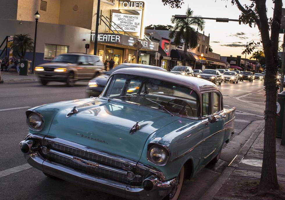 A vintage Chevrolet parked in front of the art nouveau Tower Theater movie house.
