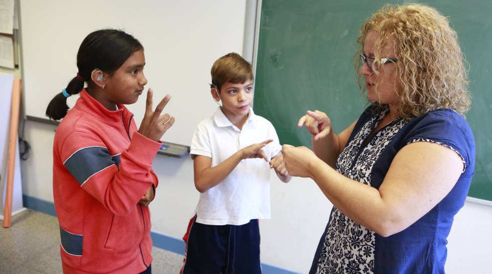 Maite, responsable de lenguaje de signos, habla con dos alumnos sordos