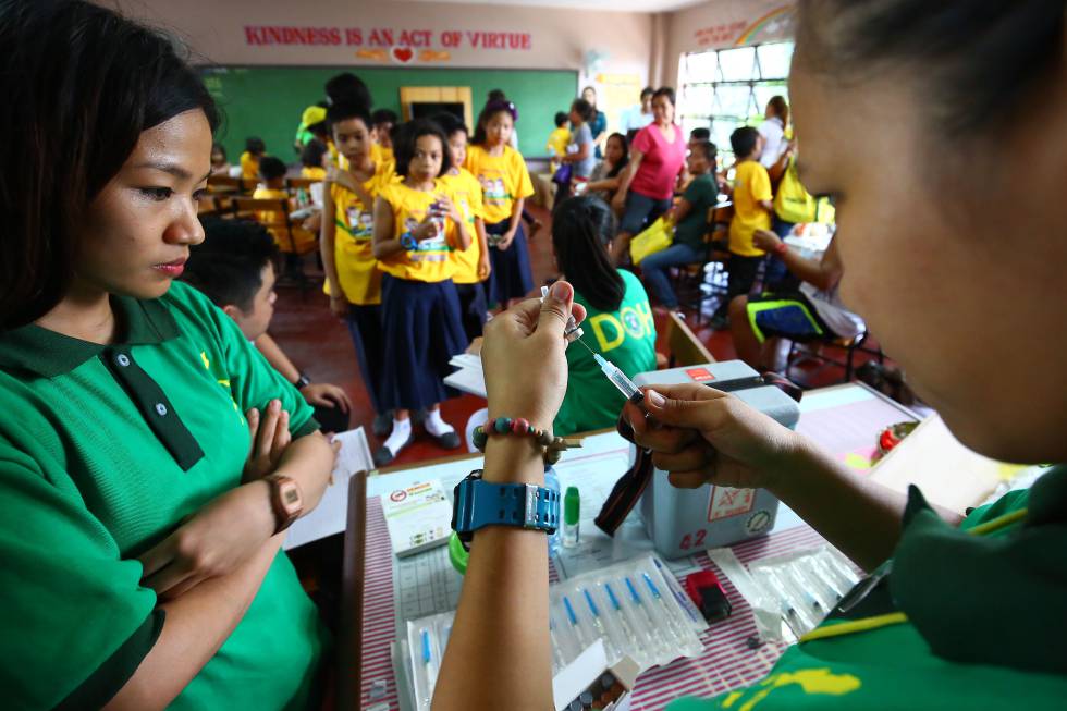 Trabajadores del Ministerio de Salud de Filipinas preparan la primera vacuna contra el dengue en una escuela de Marikina, al este de Manila.