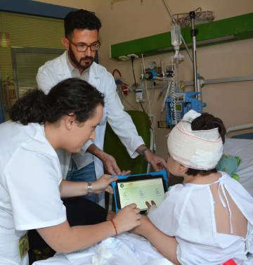 Un niño juega con PainAPPle para medir su grado de dolor postoperatorio. Un niño juega con PainAPPle para medir su grado de dolor postoperatorio.