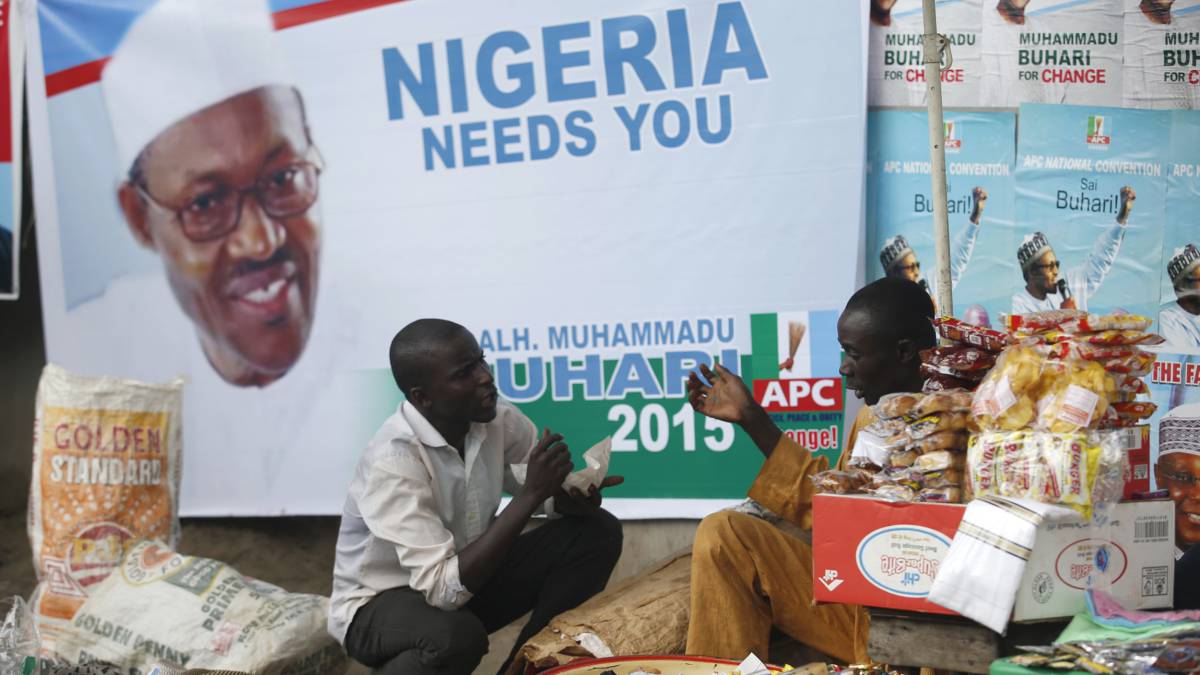 Dos vendedores junto a un cartel del presidente nigeriano Buhari. Dos vendedores junto a un cartel del presidente nigeriano Buhari.